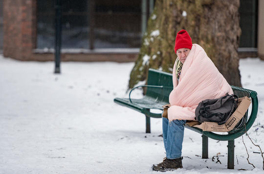 Man experiencing homelessness sat on bench