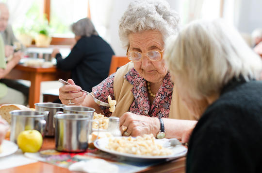 Woman having dinner in a care home
