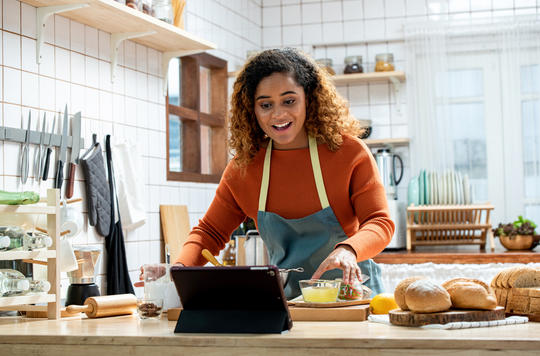Young lady baking in front of laptop