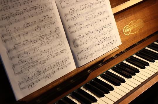 Piano with music sheets