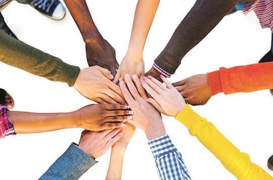 Group of people with hands held in circle