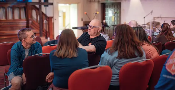 A group of people sitting together in discussion.