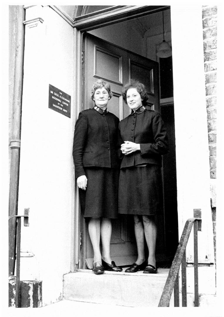 Two people standing in a doorway in the past