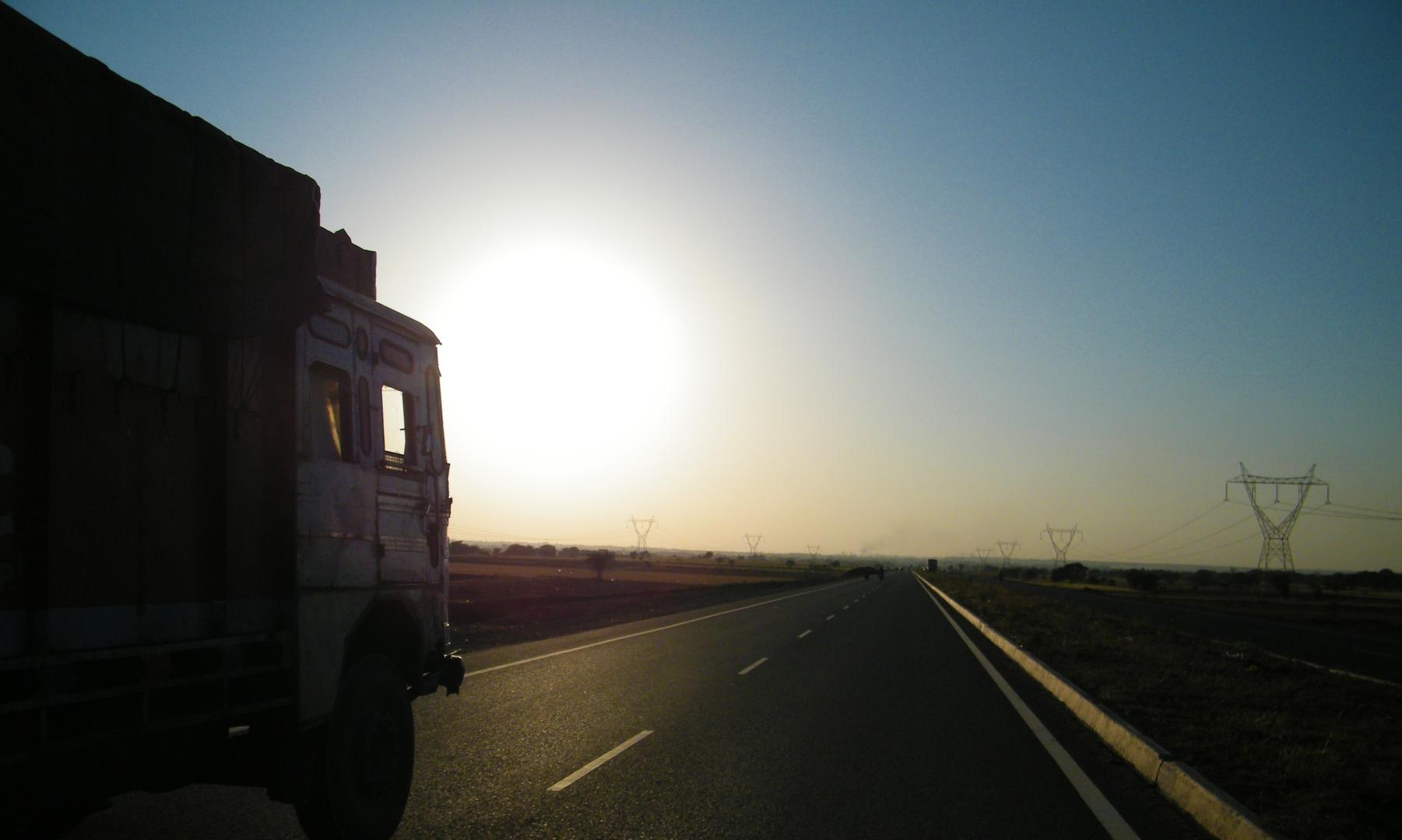 Lorry driving into either sunset or sunrise