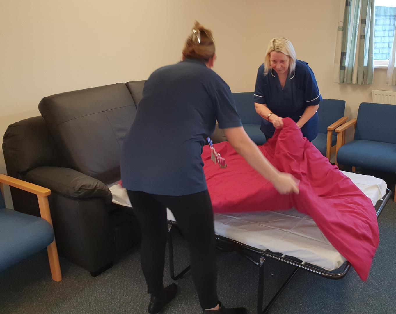 Care workers making making sofabed
