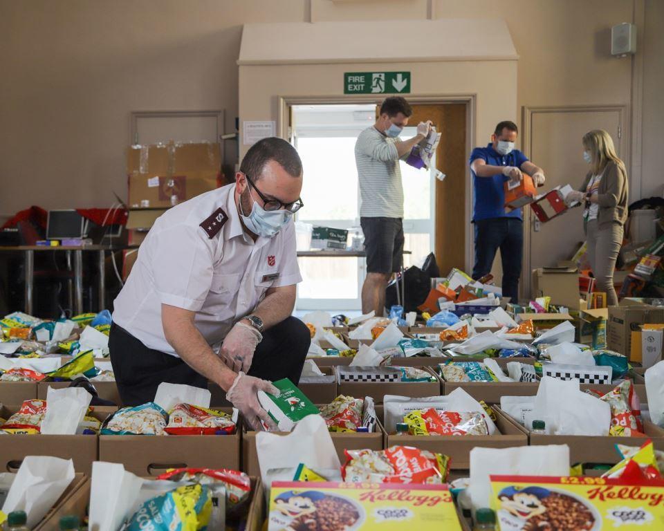 Salvation Army Officer wearing face mask packing food Parcels 