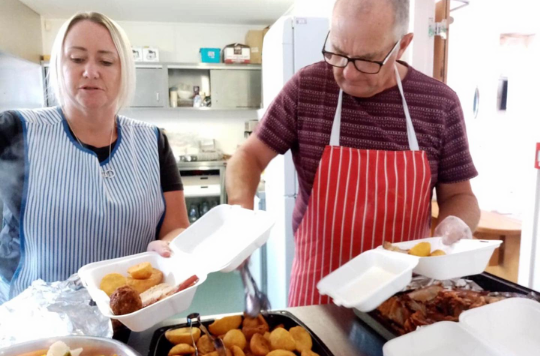 Two volunteers serve up meals at Leeds Central Salvation Army