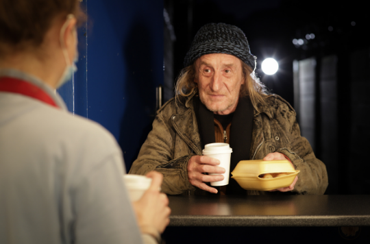 A rough sleeper receives hot food and drink