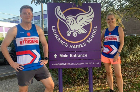 Seb Gray & Jo Ball in a Sally Army Striders running top in front of Laurance Haines School in Watford