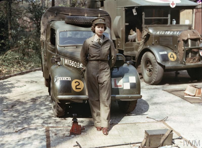 Auxiliary Territorial Service: Princess Elizabeth, a 2nd Subaltern in the ATS, wearing overalls and standing in front of an L-plated truck. In the background is a medical lorry.