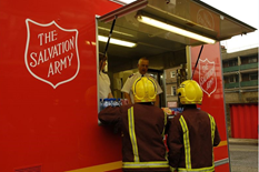 Two Firefighters receive support from Salvation Army Incident Response vehicle.