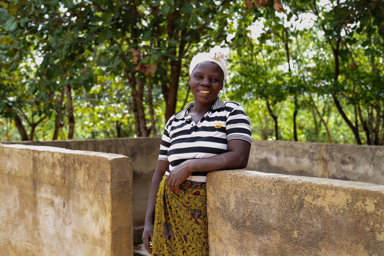 Photo of Esther stood by borehole in Malawi