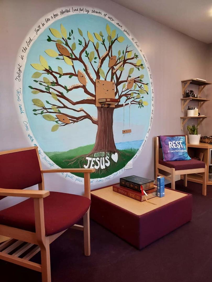 An image of a peaceful room with two chairs and a tree on the wall 
