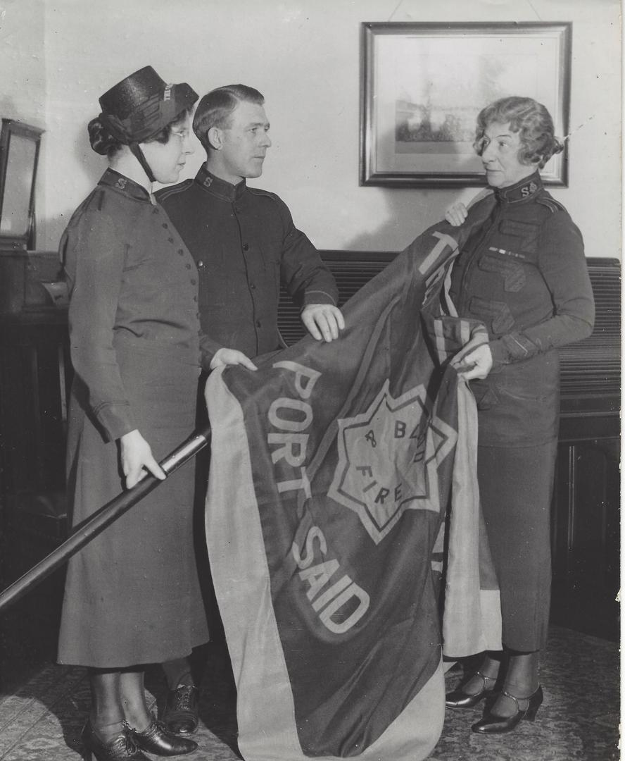 Adjutants Victor and Laura Underhill receiving a Port Said Salvation Army flag from Evangeline Booth prior to their departure to Egypt.