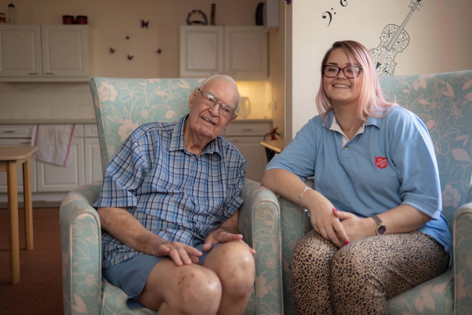 An older gentleman with a young lady wearing a blue salvation army top