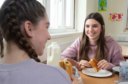 two teenage girls having breakfast at a Salvation Army summer camp.