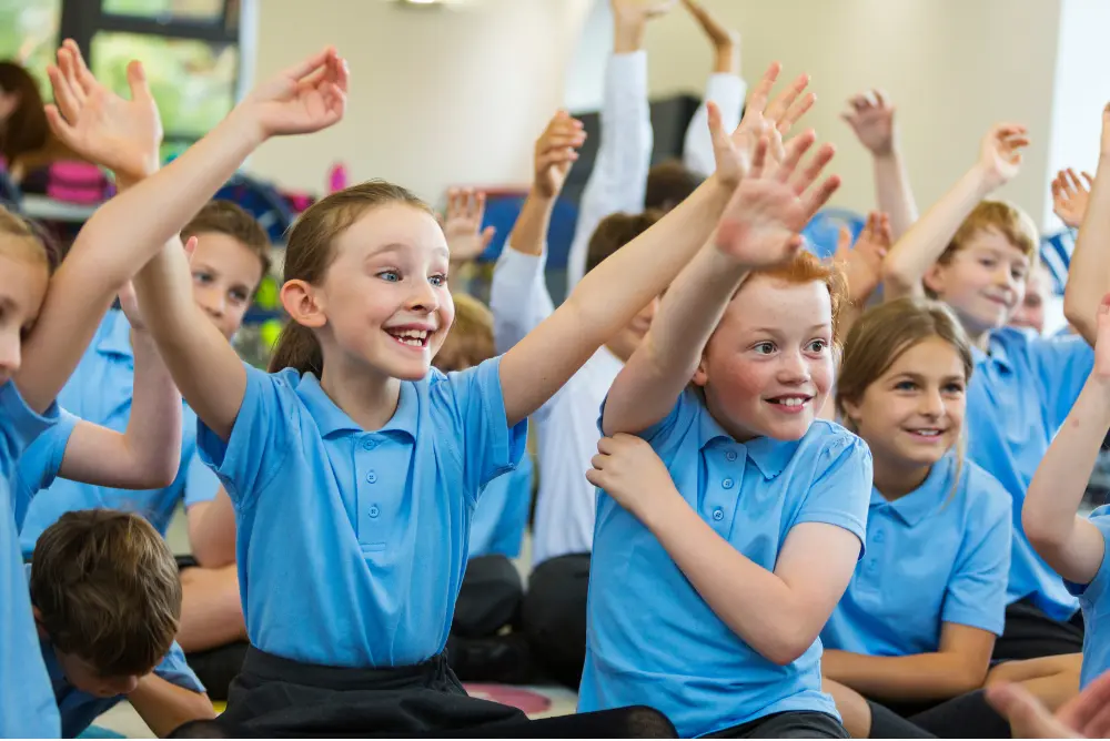 Students smiling with arms in the air