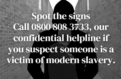 A man with his back to the camera in an alley way. The text: Spot the signs call 0800 808 3733, our confidential helpline if you suspect someone is a victim of modern slavery.