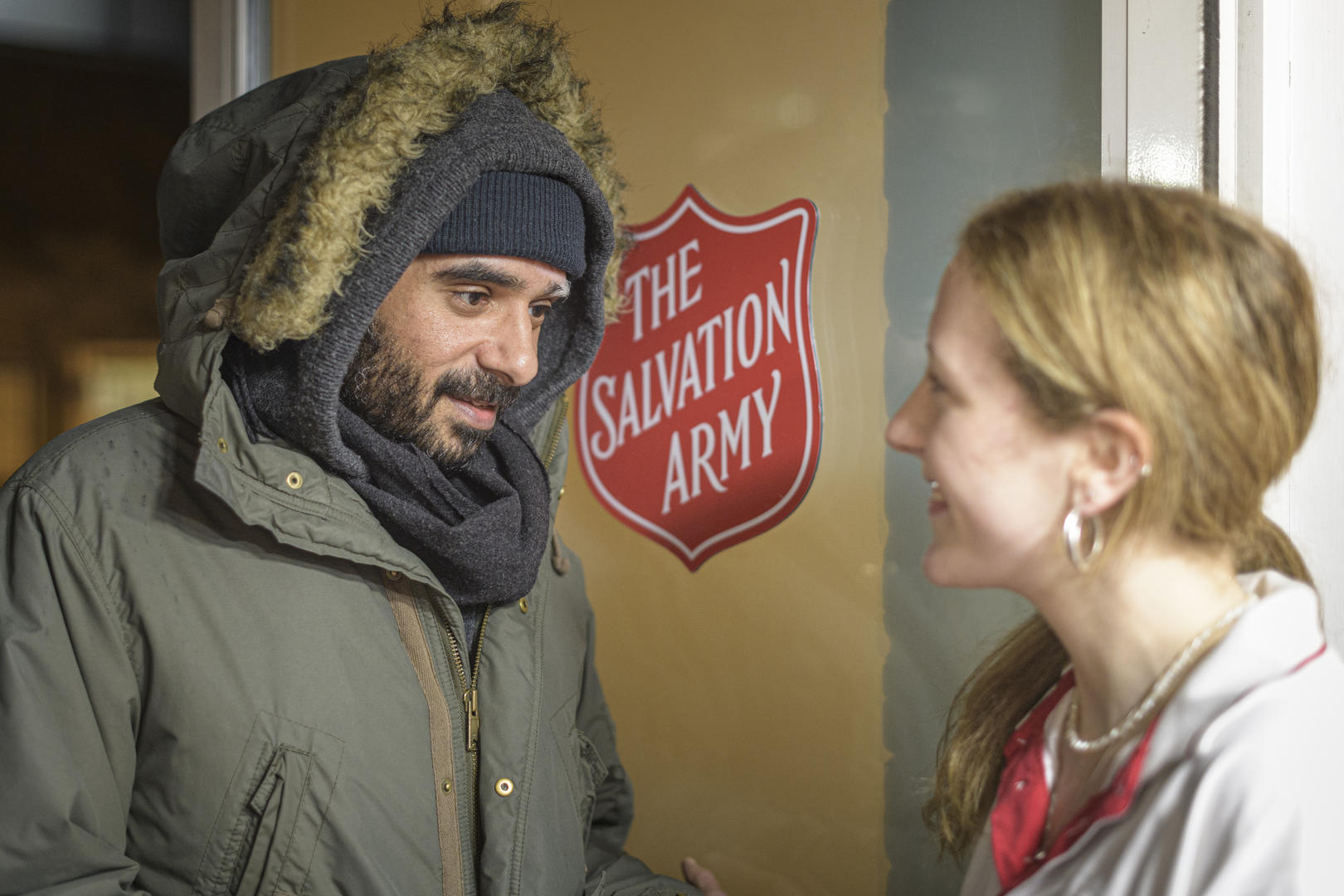 Salvation Army officer welcoming a homeless person into a Salvation Army centre
