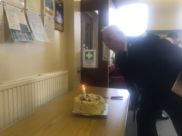 Retired Bandmaster Colin Brown blowing out the candles