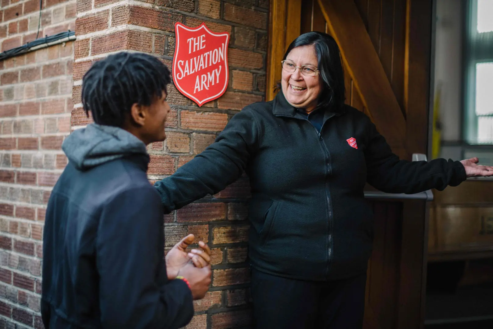 Image of woman welcoming a visitor into one of The Salvation Army centres.