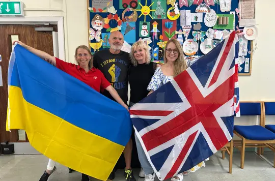 A group of people holding a Ukrainian and UK flag 