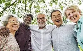 A group of older people laughing of mixed ethnicity