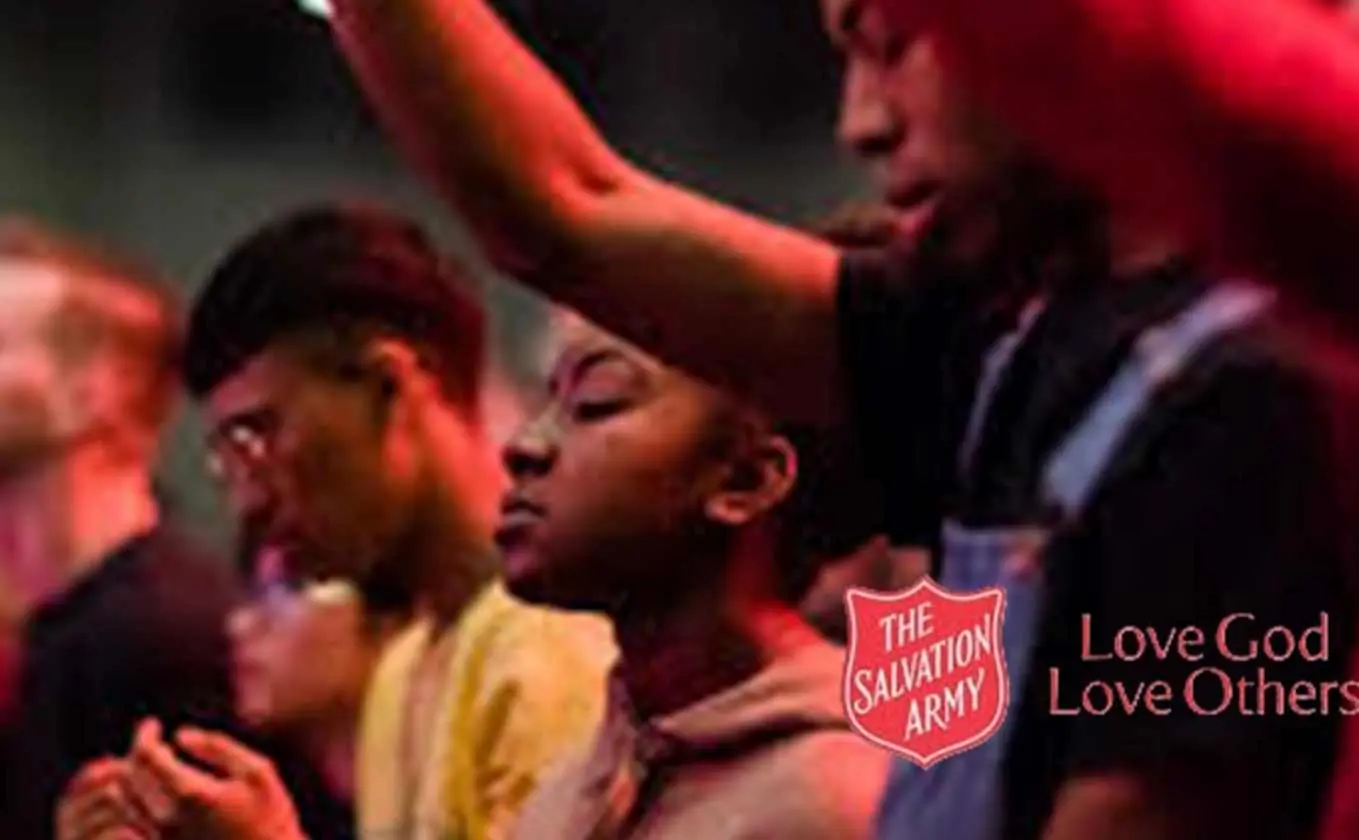 Group of People of mixed ethnicity with the red shield and words Love God Love others