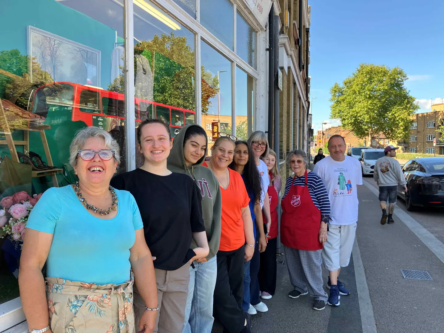Church leader, Julie Pell and charity shop manager Oya stand outside 'Sally in the Stow' charity shop with some customers