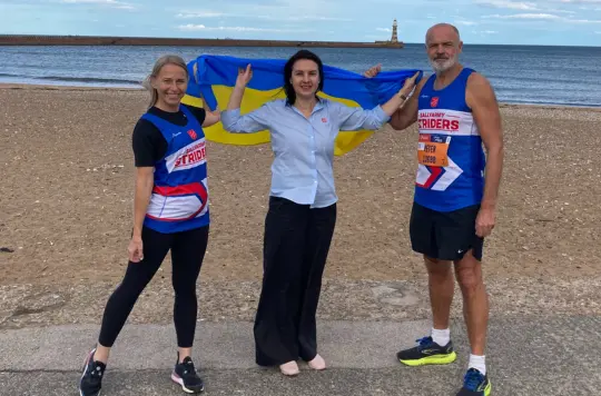 Picture of three people on seafront 