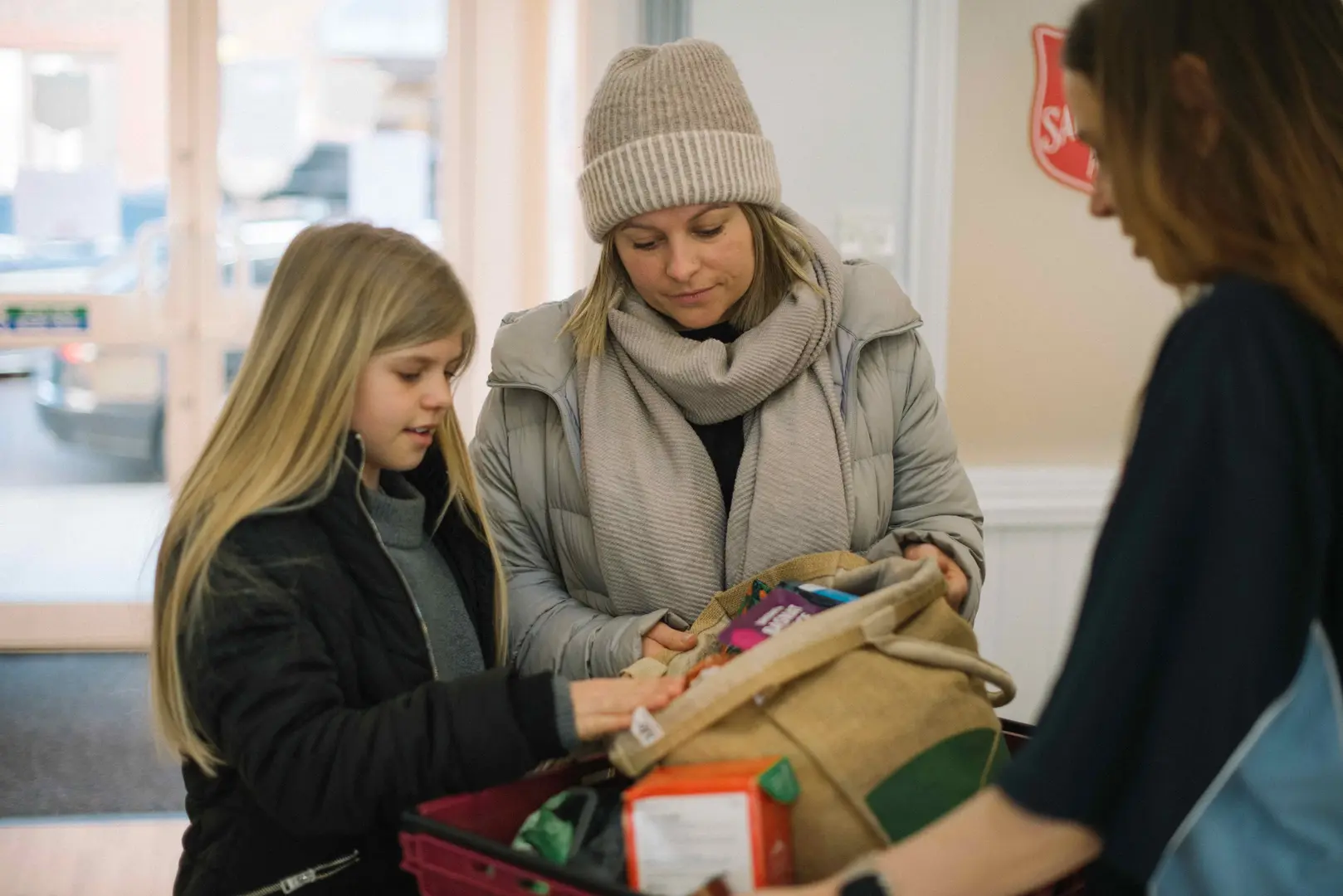 A mother and daughter being handed a good hamper