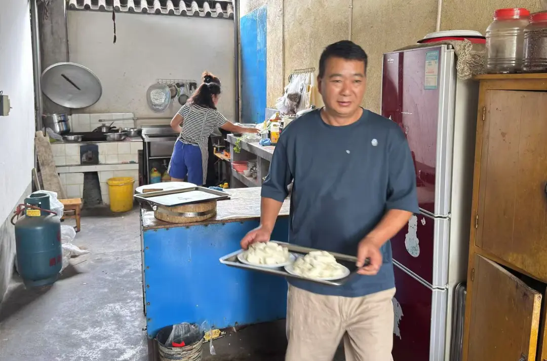 Mr Guo carrying meals in his restaurant