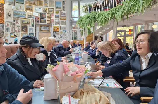 A group of people inSalvation Army uniform sat enjoying a meal 
