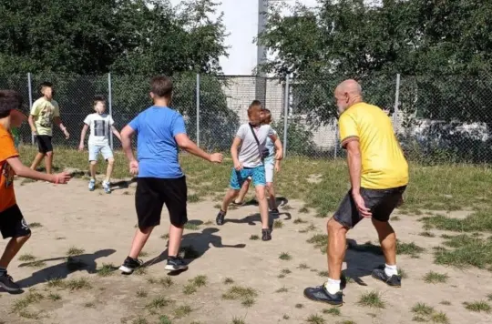 Volunteer playing football with children 