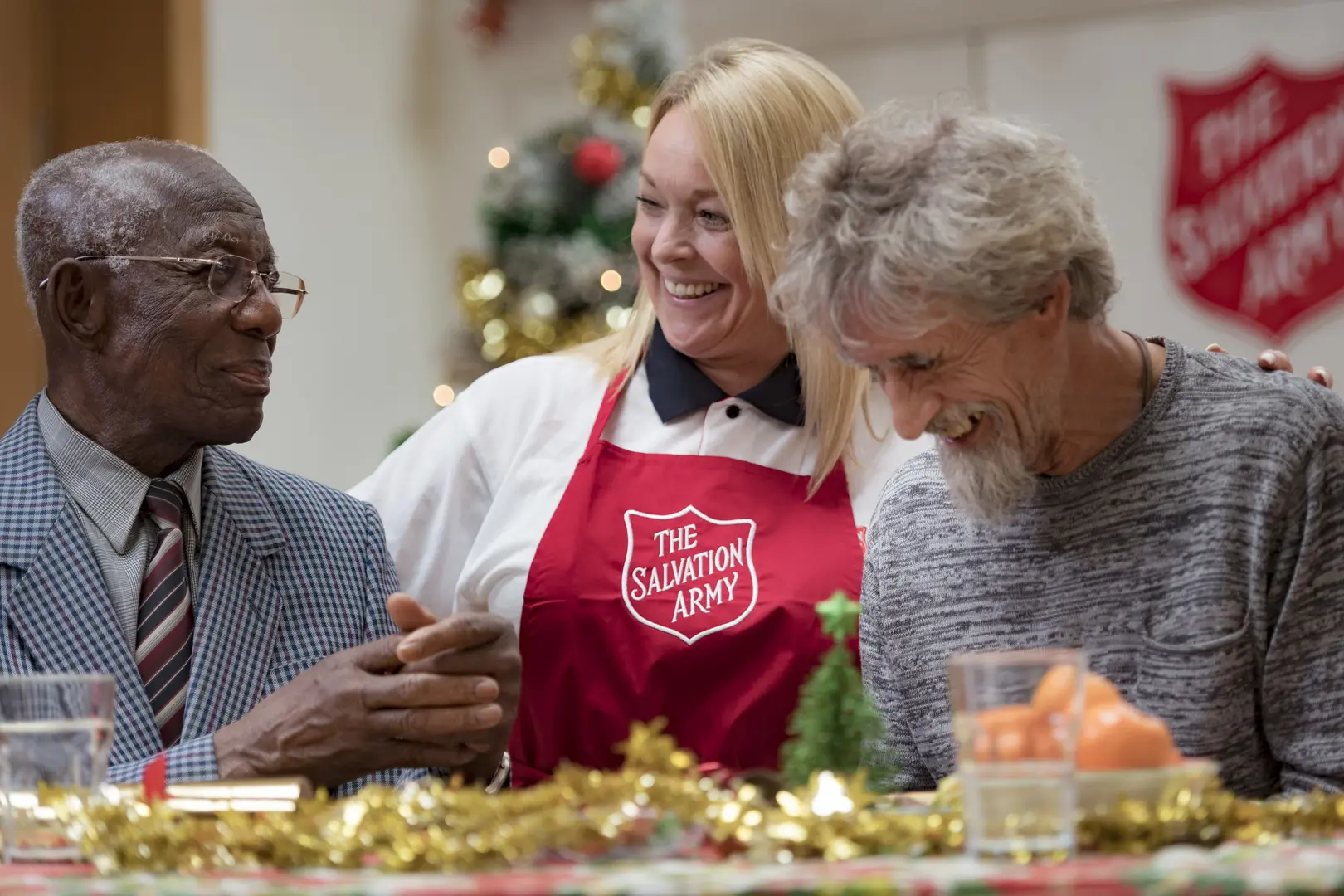 Three people enjoying a Christmas Lunch, the two women are smiling.