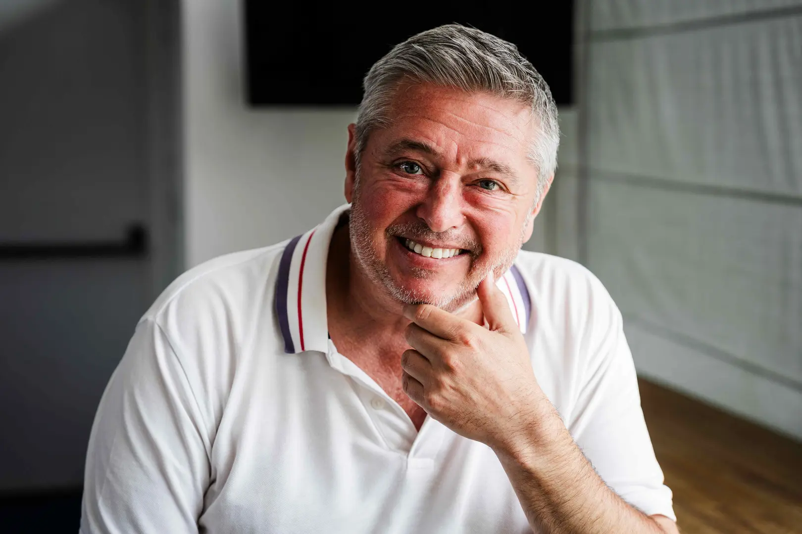 Jason, a Salvation Army beneficiary, smiles with his head resting on his hand