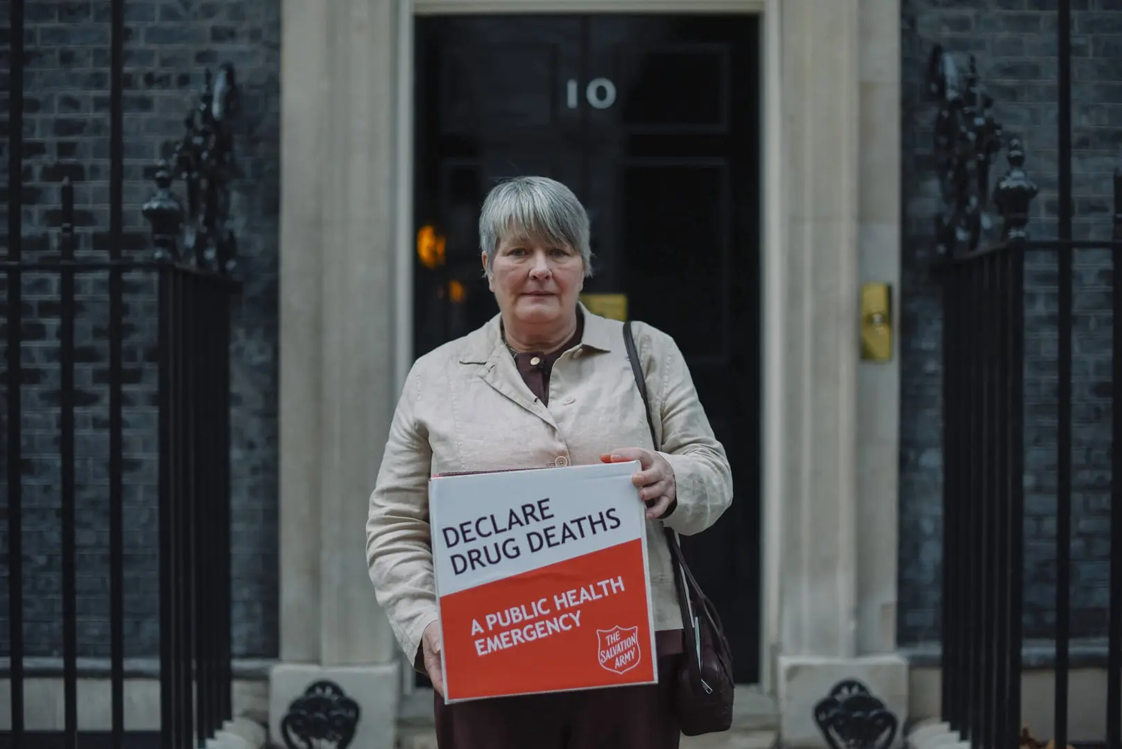 A woman pictured outside 10 Downing Street holding The Salvation Army's petition calling for the rise in drug deaths to be treated as a public health emergency