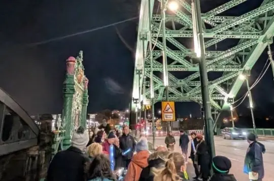 A group of people crossing a bridge