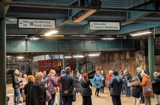A group of people gather near a train station 