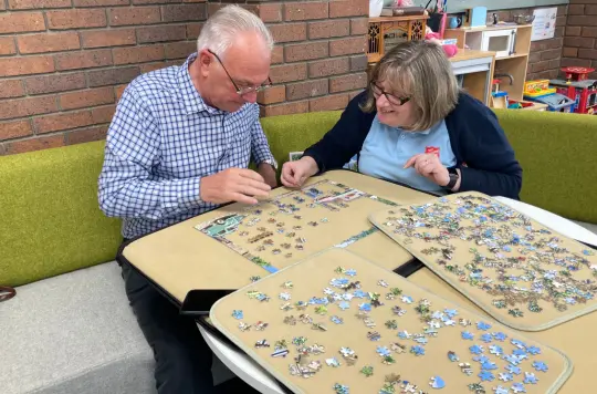 A picture of two people doing a jigsaw 