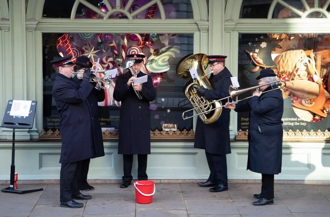 Five band members blowing trumpets