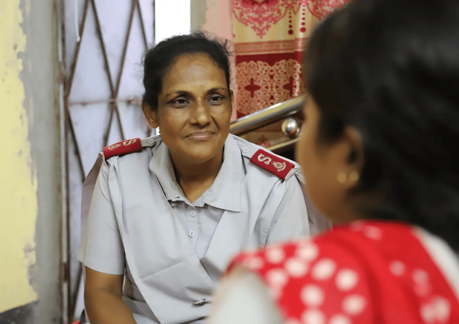 Bangladeshi Salvation Army Officer facing woman with back to camera