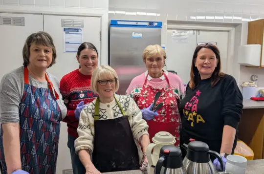 A group of festive volunteers smile at the camera 