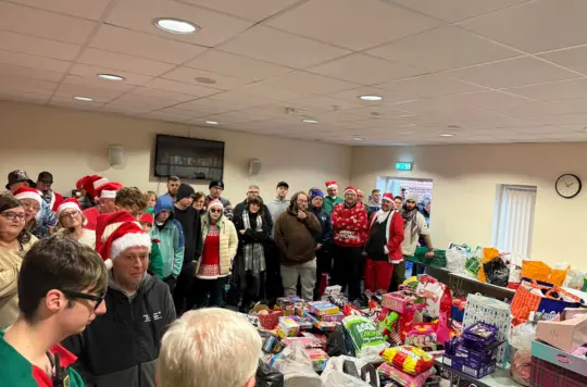 A group of people dressed festively delivering presents