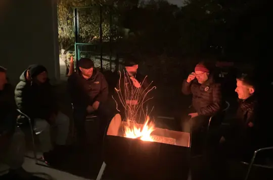 Picture of men sat round a fire 