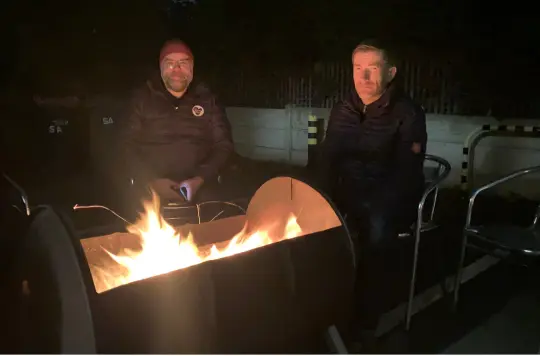 Two men around a firepit