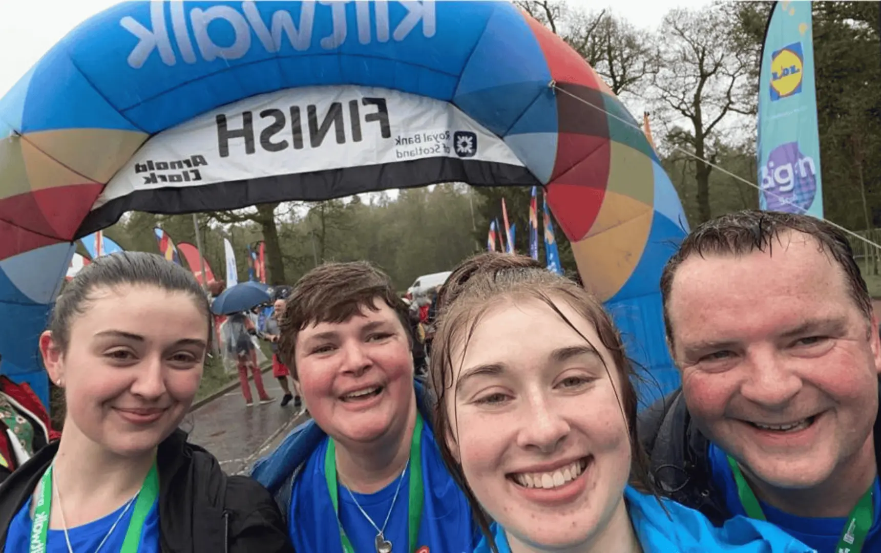 A family in Team Sally Army fundraiser shirts at the finish line of the Kiltwalk