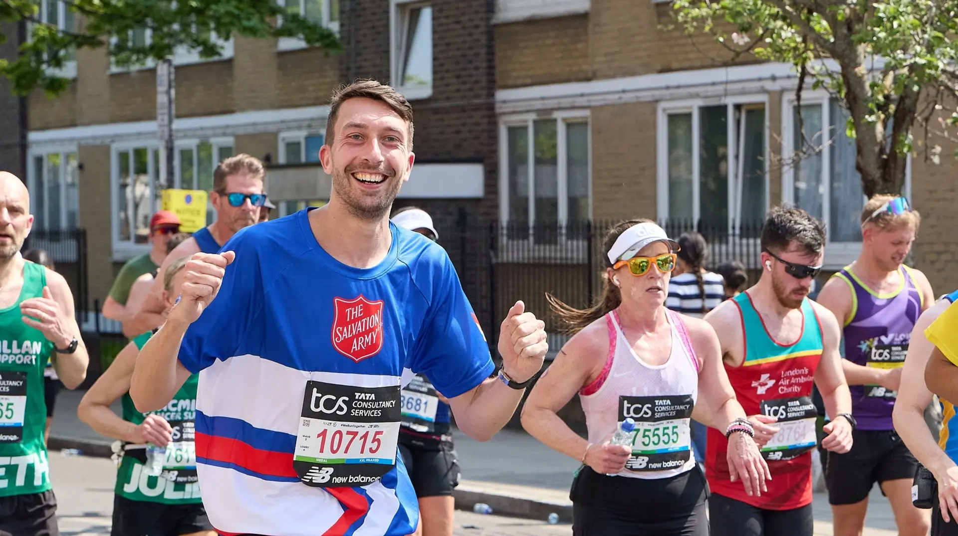 A Salvation Army runner smiling at cheerers at mile 20 of the 2025 London Marathon