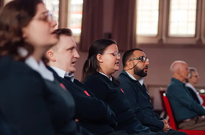 Candidates sitting in the Assembly Hall singing in worship.